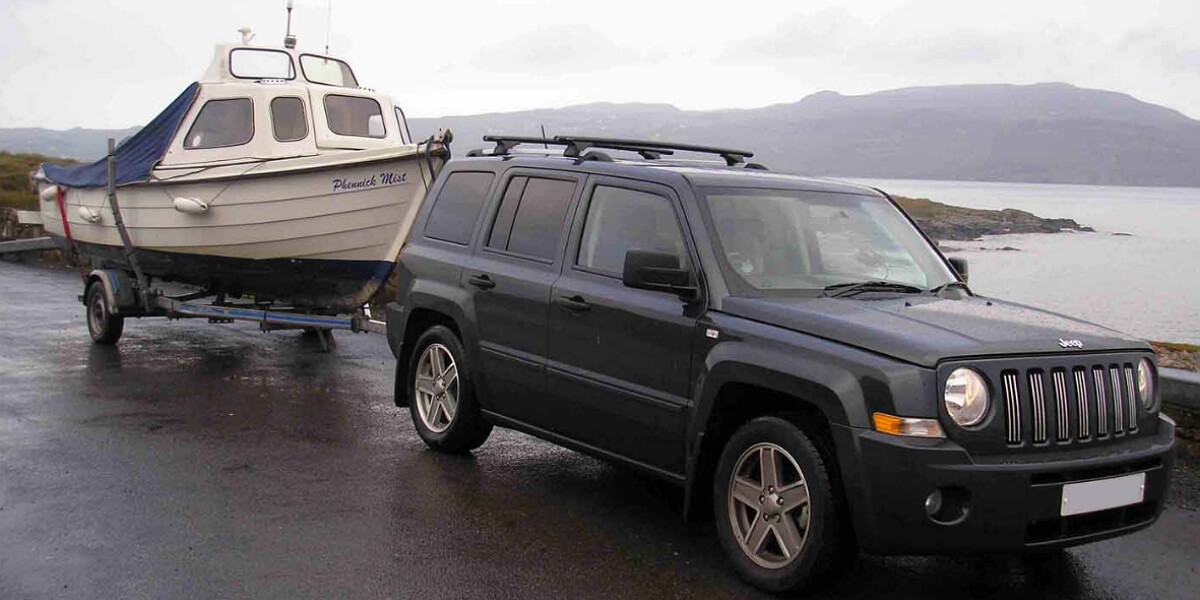 Jeep Patriot towing a boat with a hitch