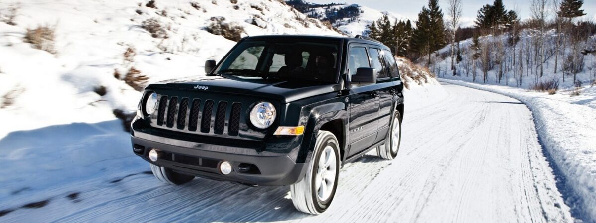 Jeep Patriot driving along the snowy mountain road
