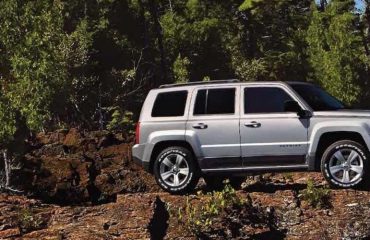 Jeep Patriot with off-road tires on rocky cliff
