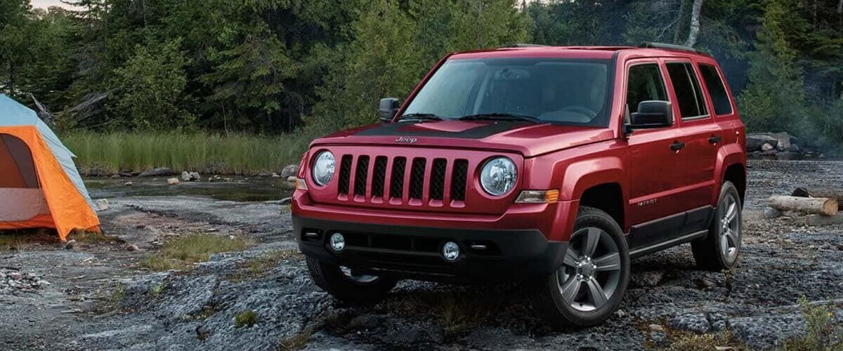 Red 2007 Jeep Patriot on a camping