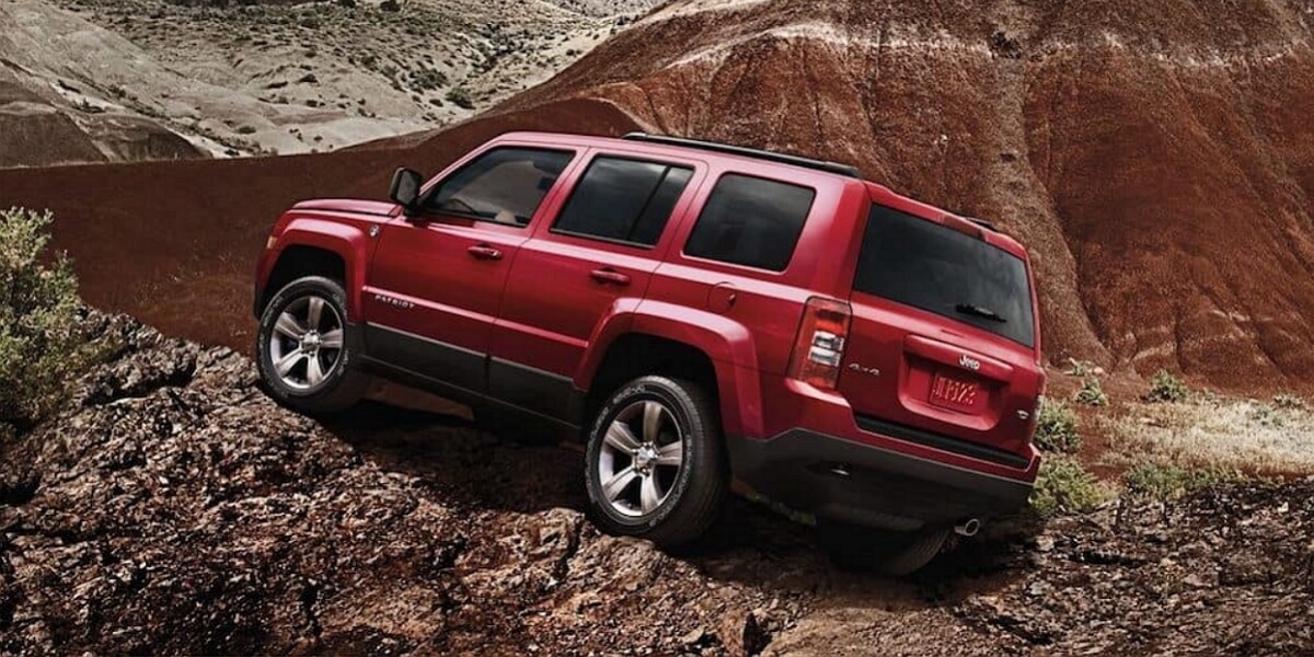Red Jeep Patriot standing on a rocky mountain
